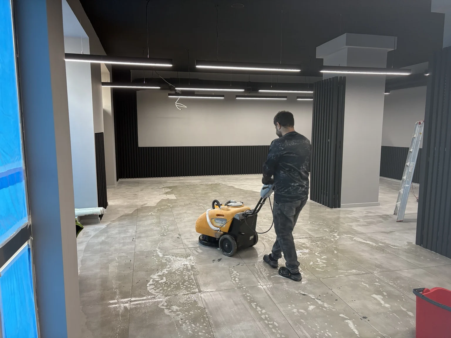 Mitarbeiter bei der maschinellen Reinigung des Salonbodens